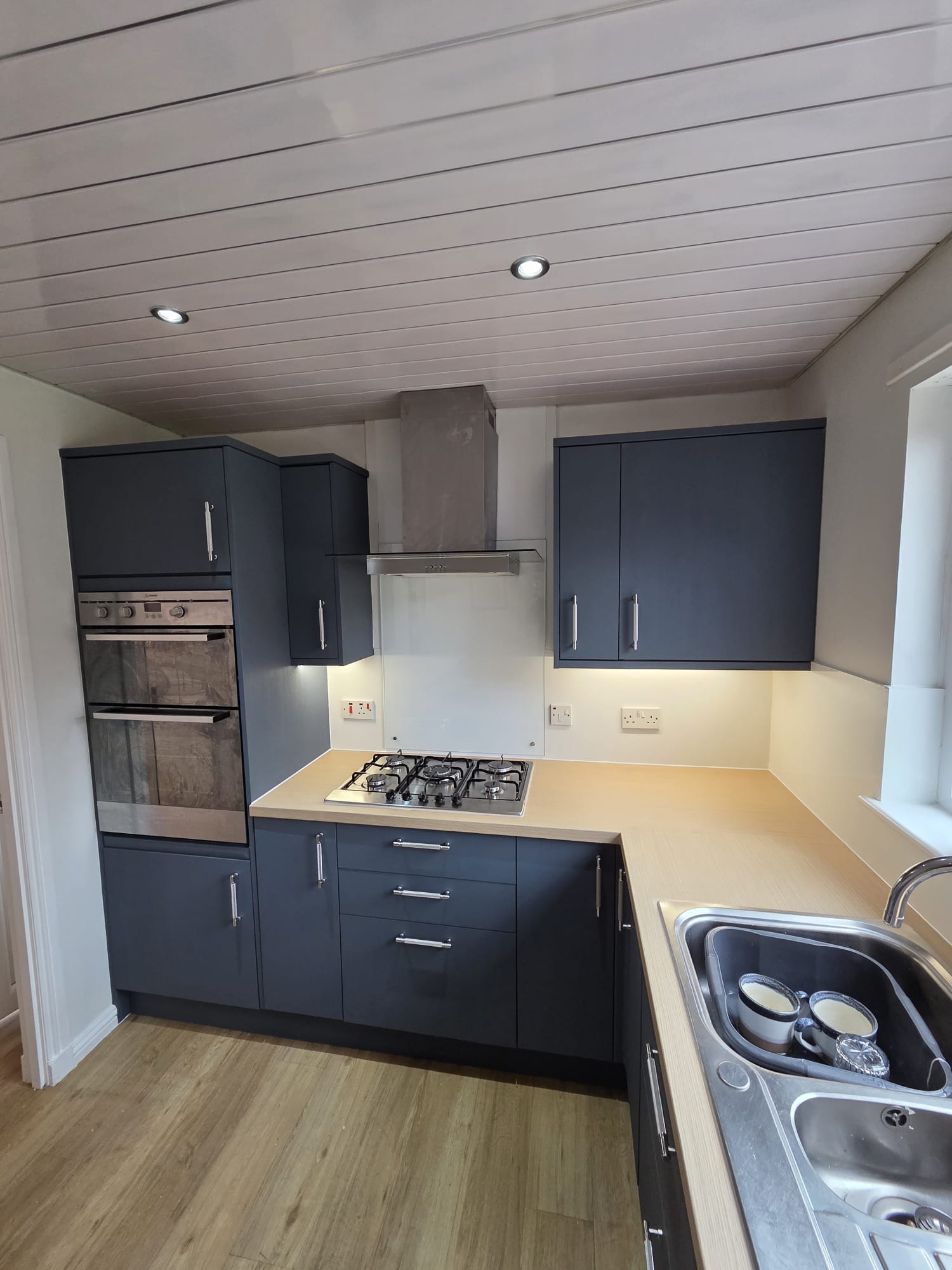Matte navy resurfaced doors and wood worktop